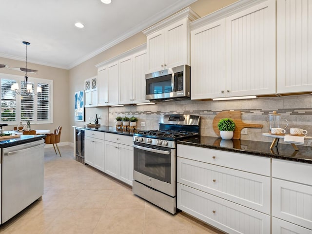 kitchen featuring white cabinetry, hanging light fixtures, beverage cooler, stainless steel appliances, and ornamental molding