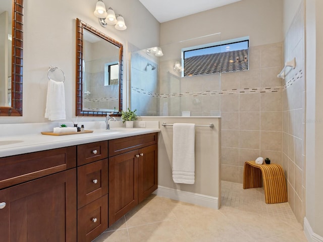 bathroom with tile patterned floors, plenty of natural light, vanity, and tiled shower