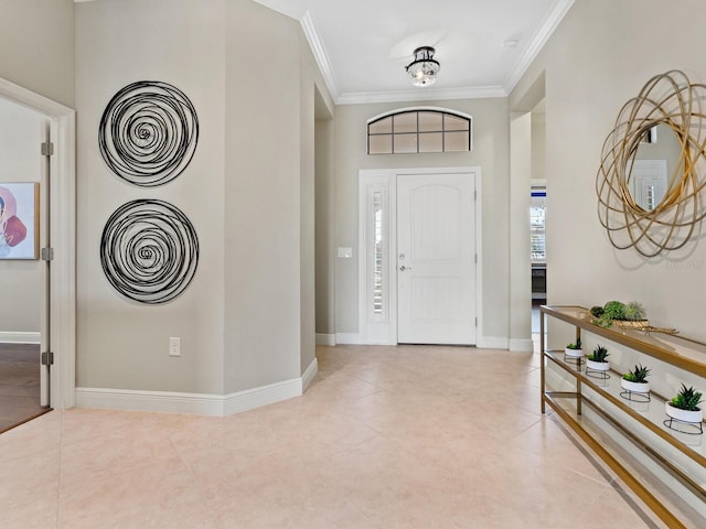 foyer with ornamental molding and light tile patterned floors