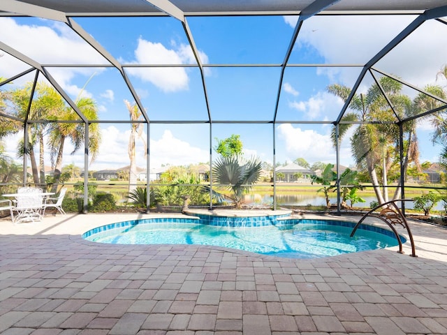 view of swimming pool featuring a water view, a patio area, and a lanai