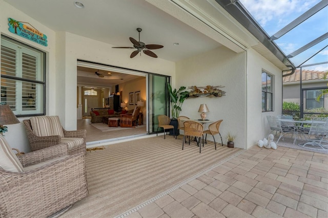 view of patio featuring glass enclosure and ceiling fan