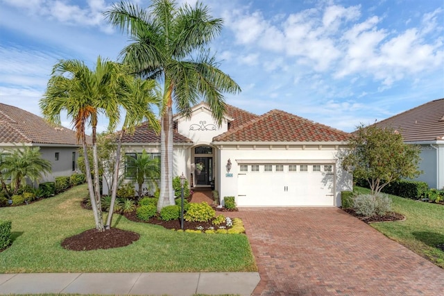 mediterranean / spanish house featuring a front yard and a garage