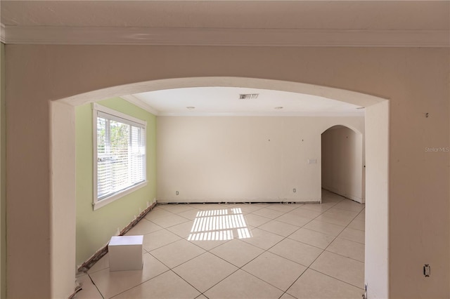 tiled spare room with ornamental molding