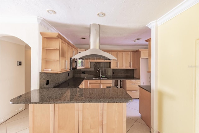 kitchen featuring light brown cabinets, decorative backsplash, light tile patterned floors, kitchen peninsula, and island exhaust hood