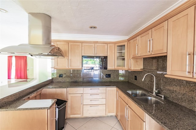 kitchen with sink, dark stone countertops, ornamental molding, light tile patterned floors, and island exhaust hood