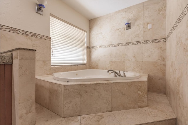 bathroom with tile walls, a healthy amount of sunlight, and tiled tub