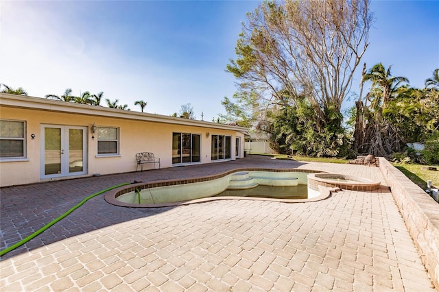 view of pool featuring a patio area, an in ground hot tub, and french doors