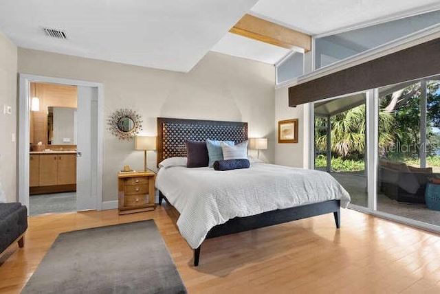 bedroom with light hardwood / wood-style flooring, access to outside, lofted ceiling with beams, and ensuite bathroom