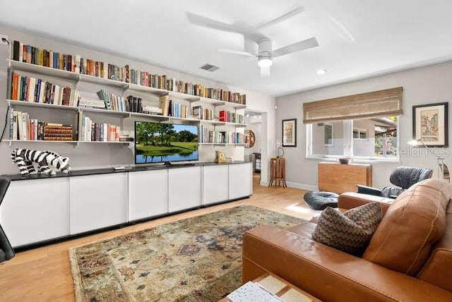 living room with ceiling fan and light hardwood / wood-style flooring