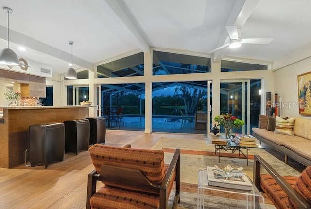 living room with vaulted ceiling with beams, hardwood / wood-style floors, and ceiling fan