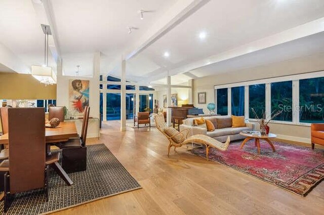 living room featuring beamed ceiling and hardwood / wood-style floors