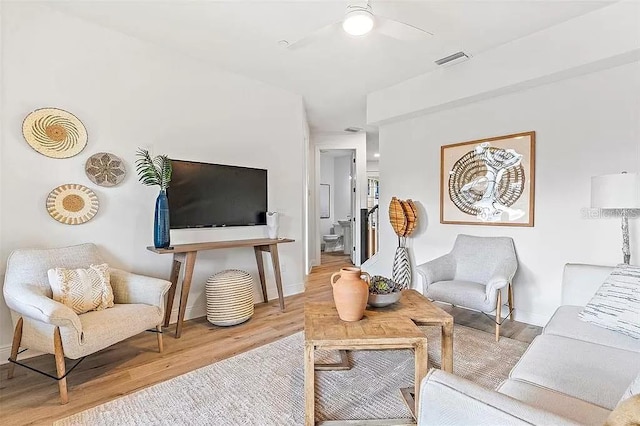 living room with light wood-type flooring and ceiling fan