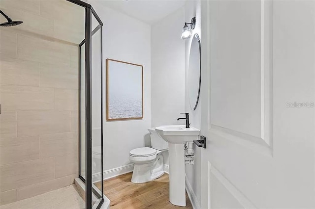 bathroom featuring hardwood / wood-style floors, sink, toilet, and walk in shower