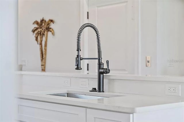 room details featuring white cabinetry and sink