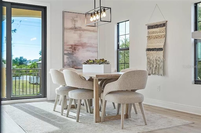 dining space with hardwood / wood-style flooring and an inviting chandelier