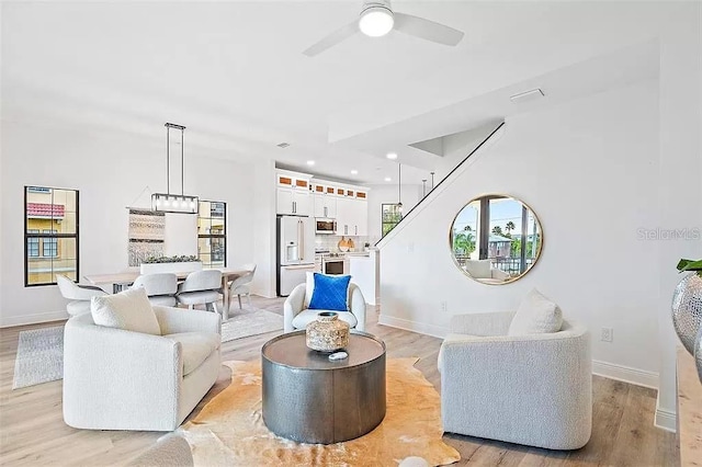 living room with ceiling fan and light wood-type flooring