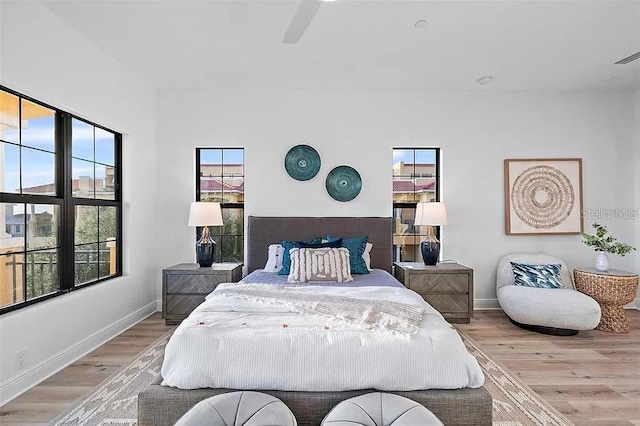 bedroom featuring multiple windows, ceiling fan, and light hardwood / wood-style floors