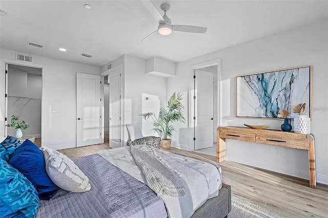 bedroom with a closet, ceiling fan, light hardwood / wood-style flooring, and a spacious closet