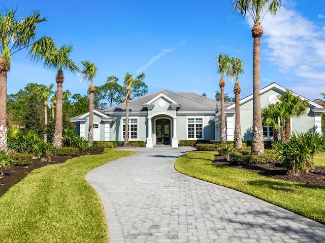 single story home featuring french doors and a front lawn