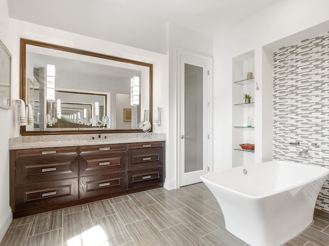 bathroom with built in shelves, a bathtub, and vanity