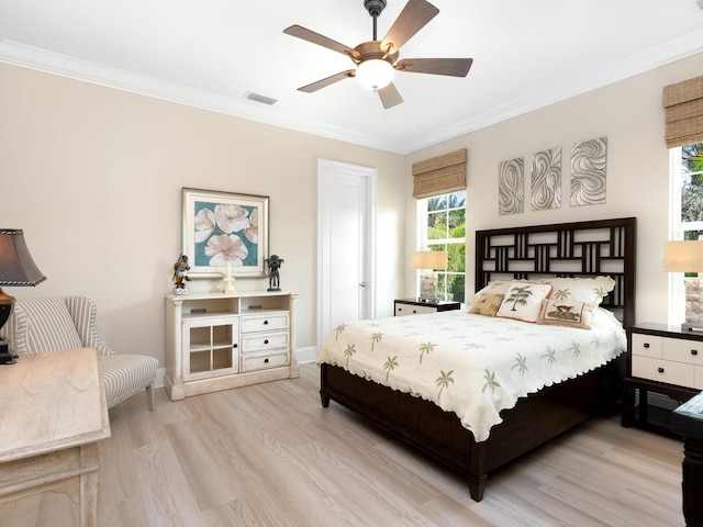 bedroom with ceiling fan, crown molding, and light hardwood / wood-style flooring