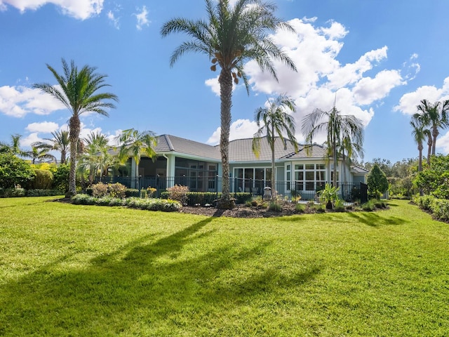 back of property with a yard and a sunroom