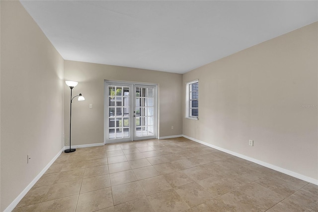 spare room with light tile patterned floors and french doors