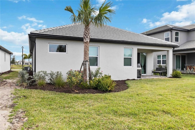 back of property featuring central AC unit and a lawn