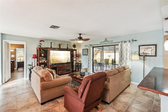 living room with ceiling fan and a textured ceiling