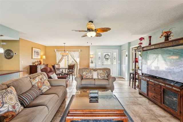 tiled living room featuring a textured ceiling and ceiling fan