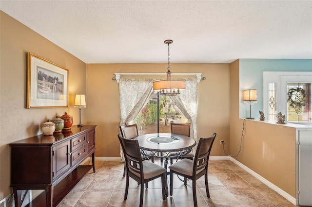 dining space featuring a textured ceiling and a notable chandelier