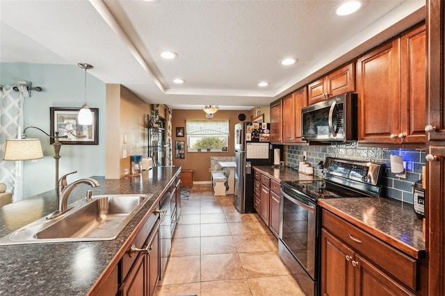 kitchen featuring tasteful backsplash, stainless steel appliances, sink, light tile patterned floors, and hanging light fixtures