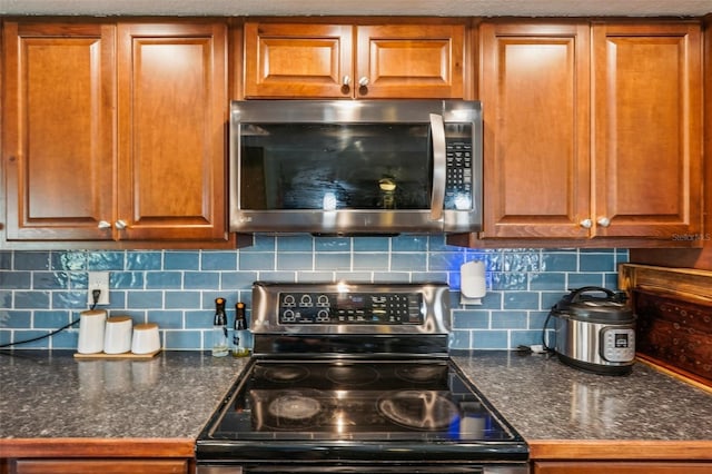 kitchen with decorative backsplash, a textured ceiling, and appliances with stainless steel finishes