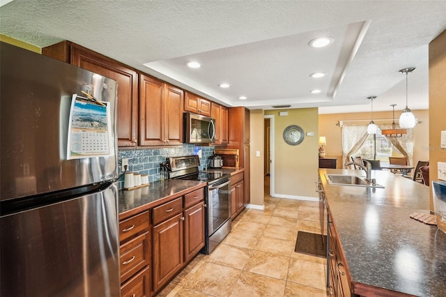 kitchen with a raised ceiling, hanging light fixtures, sink, appliances with stainless steel finishes, and tasteful backsplash