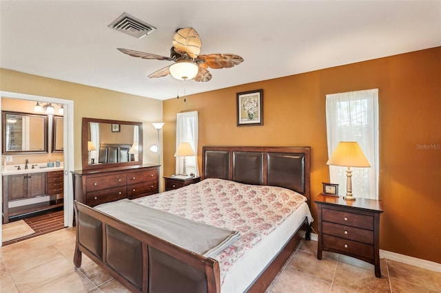 bedroom with ceiling fan, sink, and ensuite bathroom