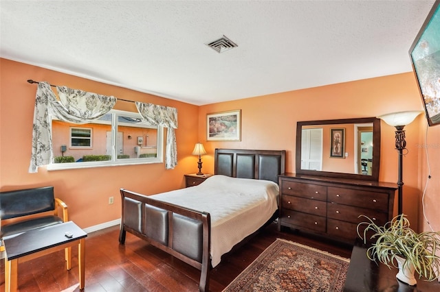 bedroom featuring dark wood-type flooring and a textured ceiling