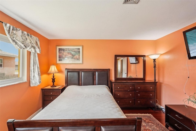 bedroom with dark hardwood / wood-style flooring