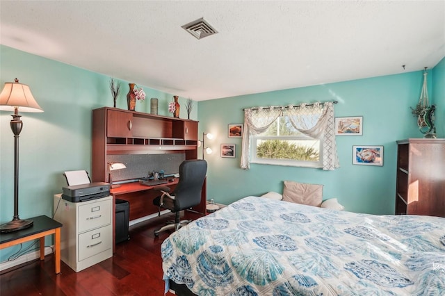 bedroom with dark hardwood / wood-style flooring and a textured ceiling