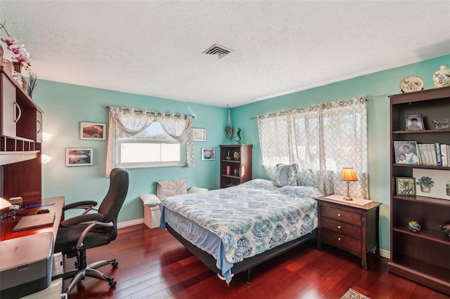 bedroom with a textured ceiling and dark hardwood / wood-style flooring