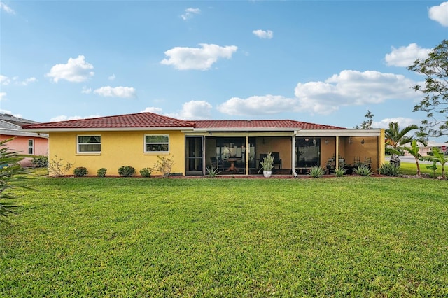 back of property featuring a yard and a sunroom