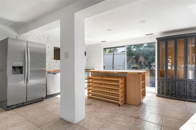 kitchen featuring tasteful backsplash, light tile patterned flooring, and stainless steel appliances