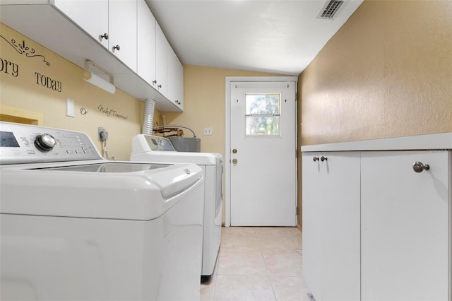 laundry area featuring cabinets, light tile patterned floors, and washing machine and clothes dryer