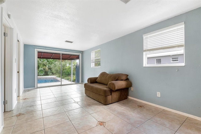 sitting room with a textured ceiling and light tile patterned floors