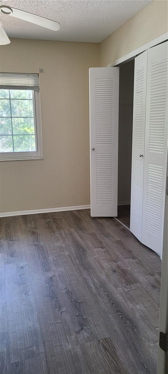 unfurnished bedroom with a closet, dark wood-type flooring, and a textured ceiling