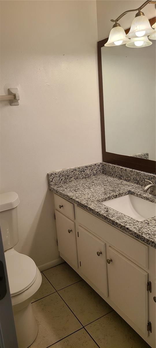 bathroom featuring toilet, vanity, and tile patterned floors