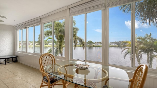 sunroom featuring a water view