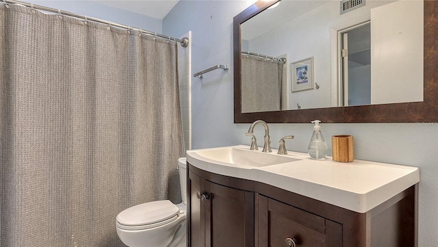 bathroom featuring curtained shower, vanity, and toilet