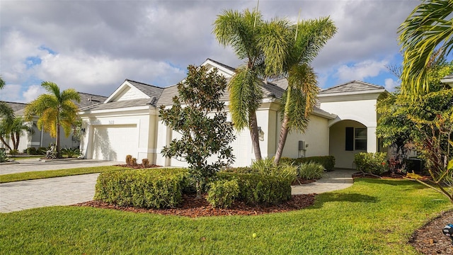 view of front of property with a garage and a front lawn