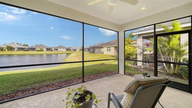 unfurnished sunroom with ceiling fan and a water view