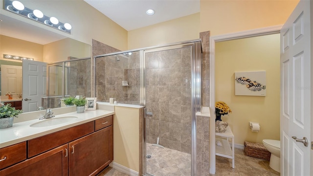 bathroom with a shower with door, vanity, and toilet